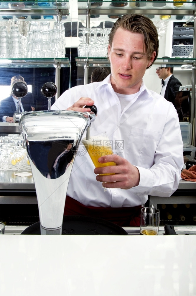 袖子餐厅他的一个酒保在镜子的反光中和顾客一起从啤酒泵里抽图片