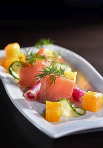 以萝卜黄瓜和橙色立方体供应咸菜鲑鱼切片蔬食物大杂烩图片