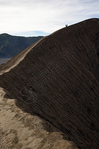 旅游勇气危险敢的徒步旅行者在环绕火山口的狭窄道路上保持平衡图片