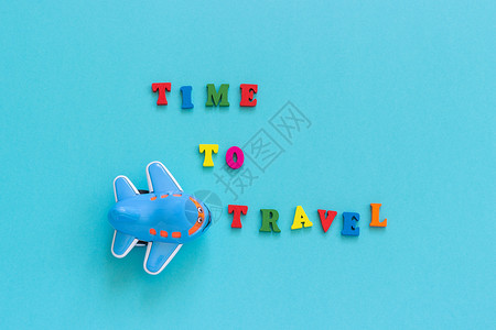 带字旅行素材运输象征问候彩色文本时间旅行和儿童有趣的玩具飞机在蓝纸背景复制空间顶视图概念旅游模板为明信片贺卡彩色文本时间旅行和儿童有趣的玩具插画