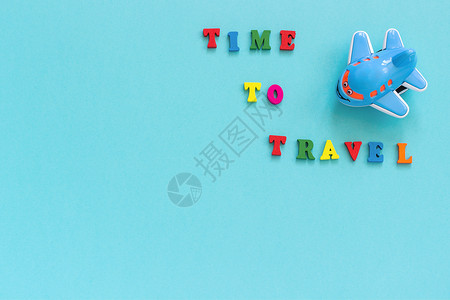 飞机贺卡素材蓝色的彩文本时间旅行和儿童有趣的玩具飞机在蓝纸背景复制空间顶视图概念旅游模板为明信片贺卡彩色文本时间旅行和儿童有趣的玩具飞机在蓝背景
