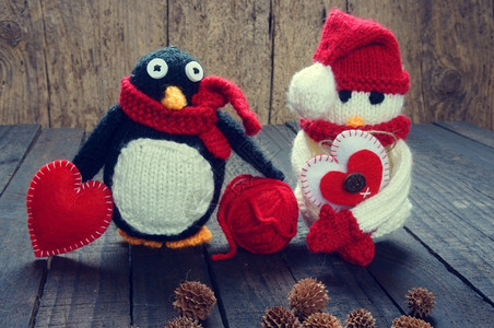 做雪人编织的Xma装饰品手工制雪人用红白羊毛做企鹅编织这是圣诞节日的玩具带有松锥果的抽象背景礼品卡红心锥体手工制作的松果背景