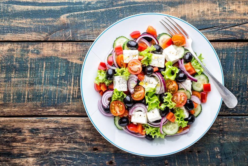 健康希腊沙拉新鲜黄瓜番茄甜辣椒生菜红洋葱乳酪和橄榄及油素食主义者午餐图片