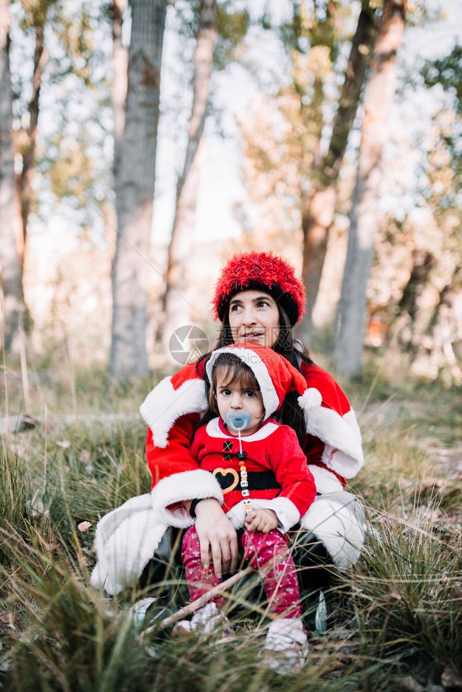 季节母亲和女儿伪装成圣诞假在森林上安息的座位礼物胡须图片