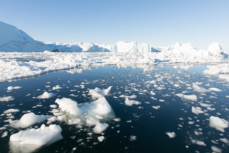 变暖激烈的风景优美丽冰山在迪斯科湾格陵兰岛伊卢利萨特周围的蓝色天空图片