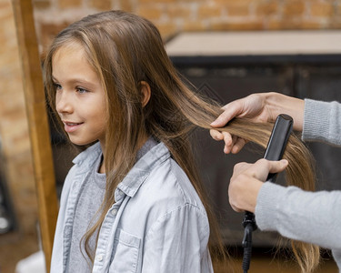 小女孩让美容师理她的头发面具顾客美师图片