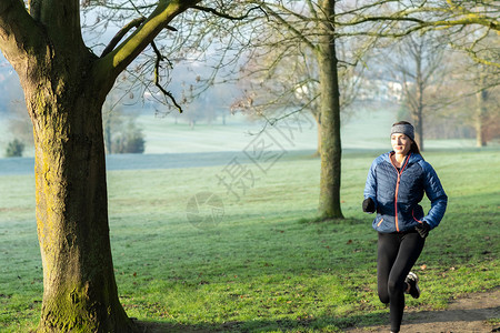 水平的幸福妇女通过公园保持运动锻炼在清晨的冬季跑二十多岁图片