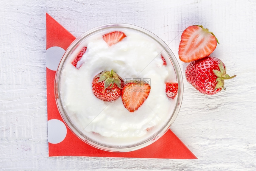营养绿色和草莓酸奶在一木碗里用白本底勺子图片
