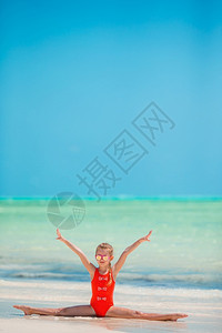 白沙滩上运动的小女孩活跃在白沙滩上玩得开心闲暇支撑可爱的图片