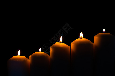宁静黄色的浪漫5支光火蜡烛在黑色背景上闪亮燃烧图片
