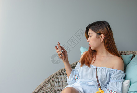 亚裔妇女使用手机智能生活于女中的亚洲现代房间图片