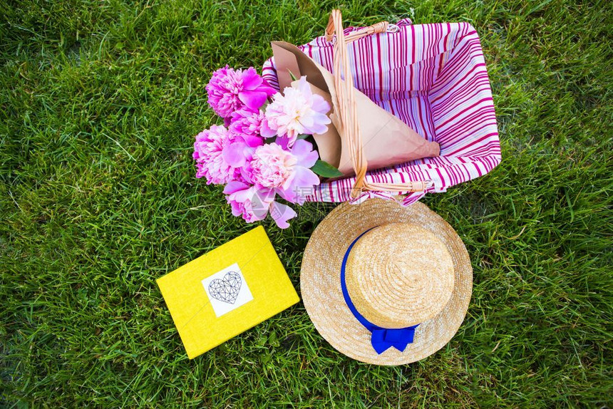 草亮说谎在篮子和黄色专辑中的美丽花朵躺在草布野餐上自然的狂欢朝鲜蓟图片