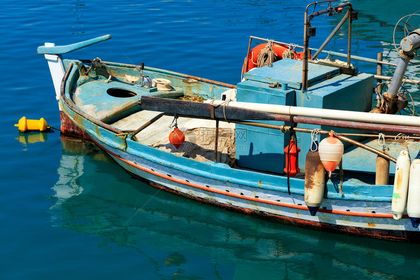 地中海一艘旧木制渔船上面有举起的桨和明亮塑料浮标停靠在爱奥尼亚海的蓝色水面上其图象是复制空间一艘老渔船挂在爱奥尼亚海的清晰水域上图片