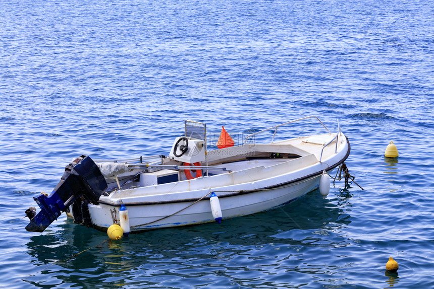 天航海的一艘渔船停泊在爱奥尼亚海的清澈绿水中有一辆高架发动机Loutraki希腊一艘机动船停泊在爱奥尼亚海的清阔水域欧洲图片