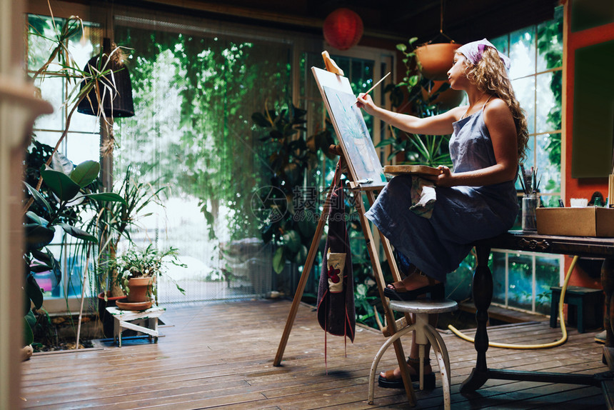 灵感框架画家与工厂一起在作室的画布上拍摄专业女艺术家绘画的室内镜头图片
