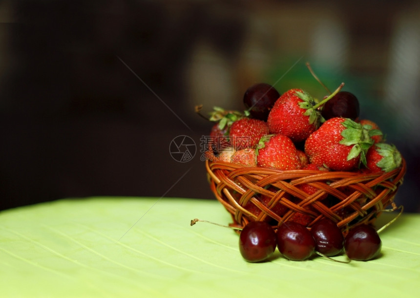 深底有大草莓和樱桃的小型棕色柳篮子摄影盒多汁的图片