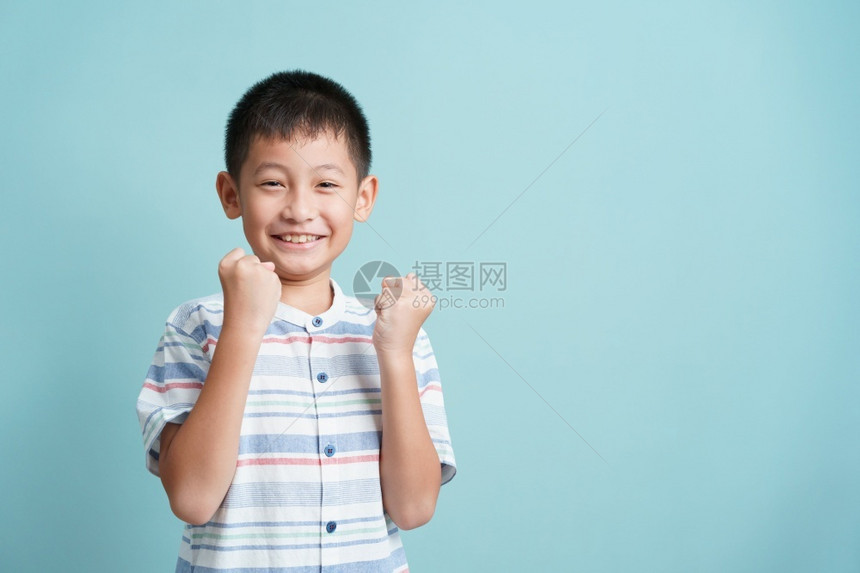 幸福吸引人的颜色亚洲快乐小男孩站在蓝色背景的亚洲小男孩孤立地站着可爱男人的肖像成功快乐和微笑图片