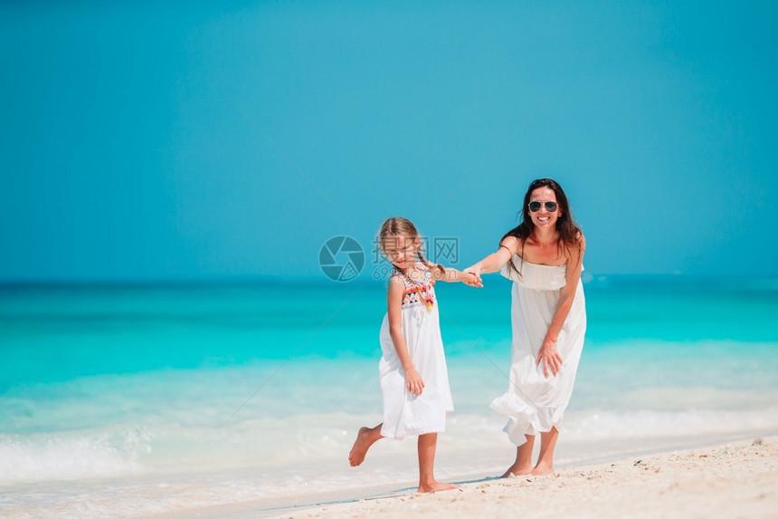 加勒比人妈海岸线年轻美丽的母亲和她可爱小女儿在热带海滩上美丽的母亲和女儿在加勒比海滩上美丽的母亲和女儿图片