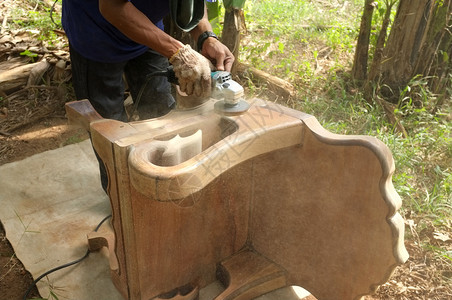 工人贴近用手持电动洗涤器清木材椅子的匠制品门图片