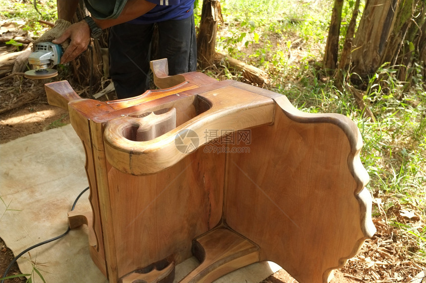 手工制作的贴近用手持电动洗涤器清木材椅子的匠头门图片