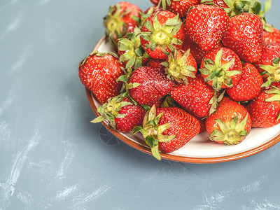 草莓放在浅蓝色背景的白盘中浅蓝色背景的草莓盘一顿饭美丽的茶点图片