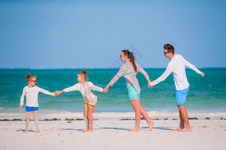 微笑热带暑假在沙滩上快乐的一家人度假年轻家庭玩得很开心母亲图片