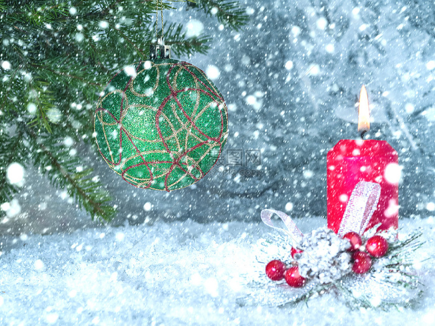 白色的圣诞树球在枝上红蜡烛在大雪下燃烧季节火焰图片