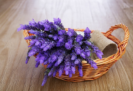 紫色篮子花朵自然乡村的在旧木制桌边篮子里放着一捆熏衣草花背景