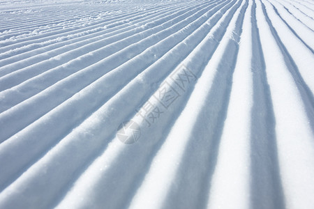 阿尔卑斯山采取美容师滑雪猫作为纹理背景所留下的滑雪斜坡上几何轨道线图片