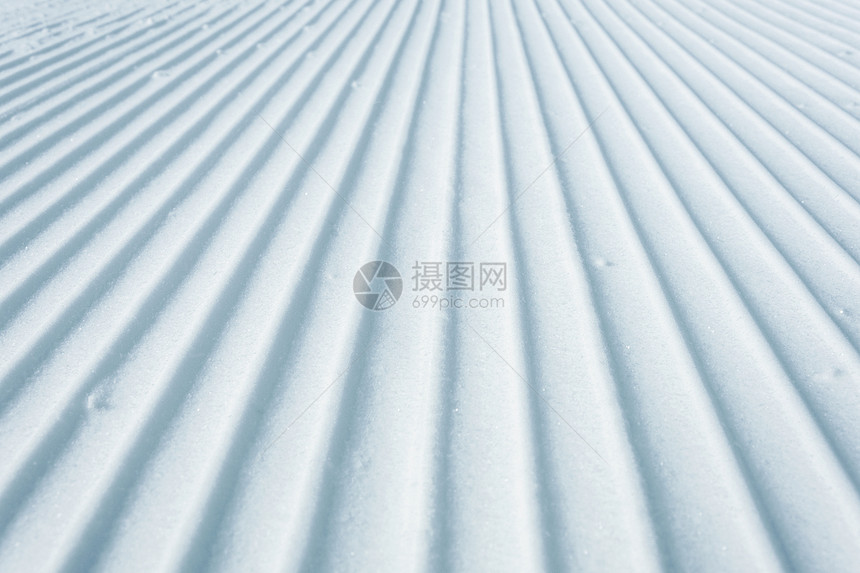 追踪痕迹线条滑雪猫作为纹理背景所留下的滑雪斜坡上几何轨道线图片