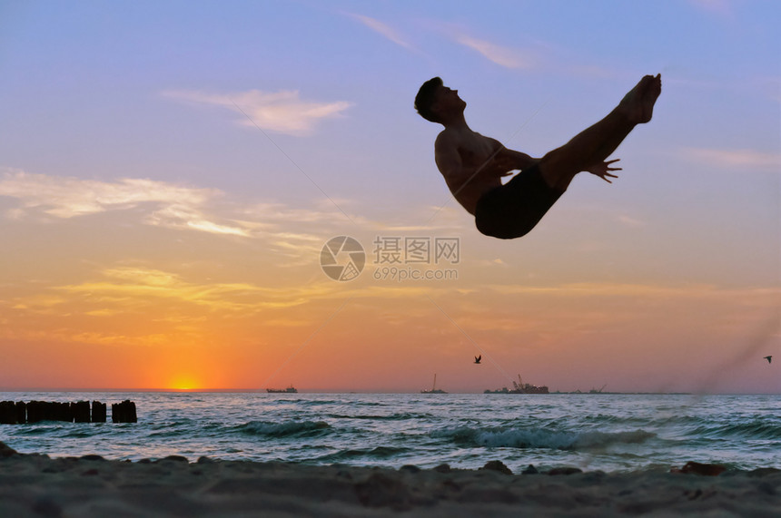 太阳海岸日落滩滑坡上的洋杂技赛事岸日落时的体操场海滩回旋以及海边的回旋蓝色健康图片