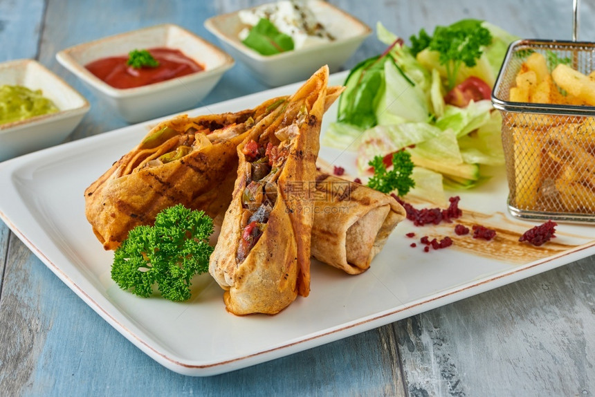 沙威玛厨房快速地木桌上白盘土耳其坦图尼配上各种酱汁和薯条木桌上白盘土耳其坦图尼配上各种酱汁和薯条图片