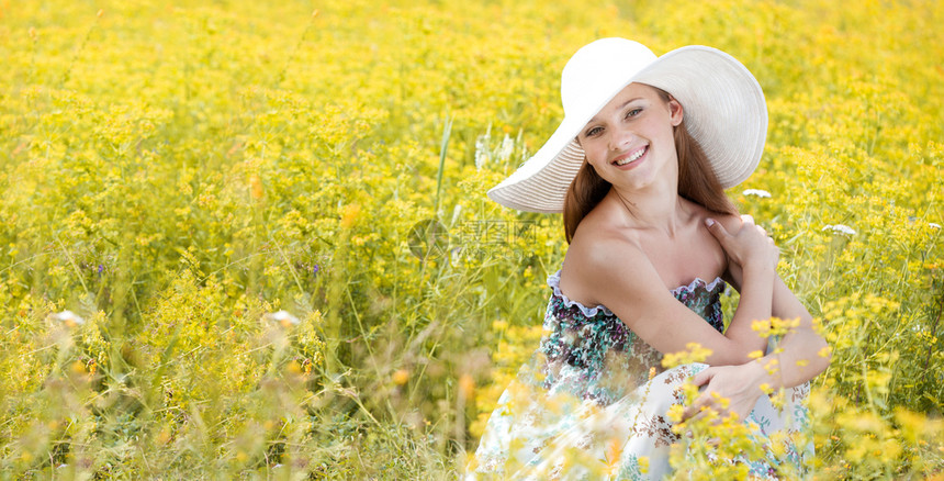在黄草地上戴着白帽子坐的快乐少女森林白色的自然图片