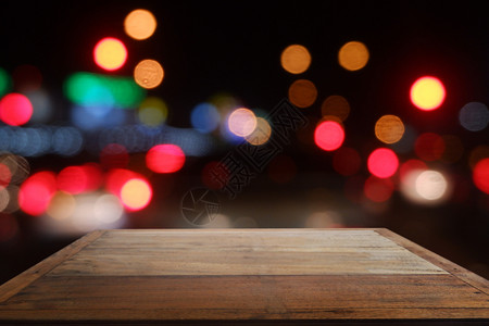 夜里餐厅咖啡的空木板桌面对着抽象的模糊bokoh灯光明亮的柜台空白图片