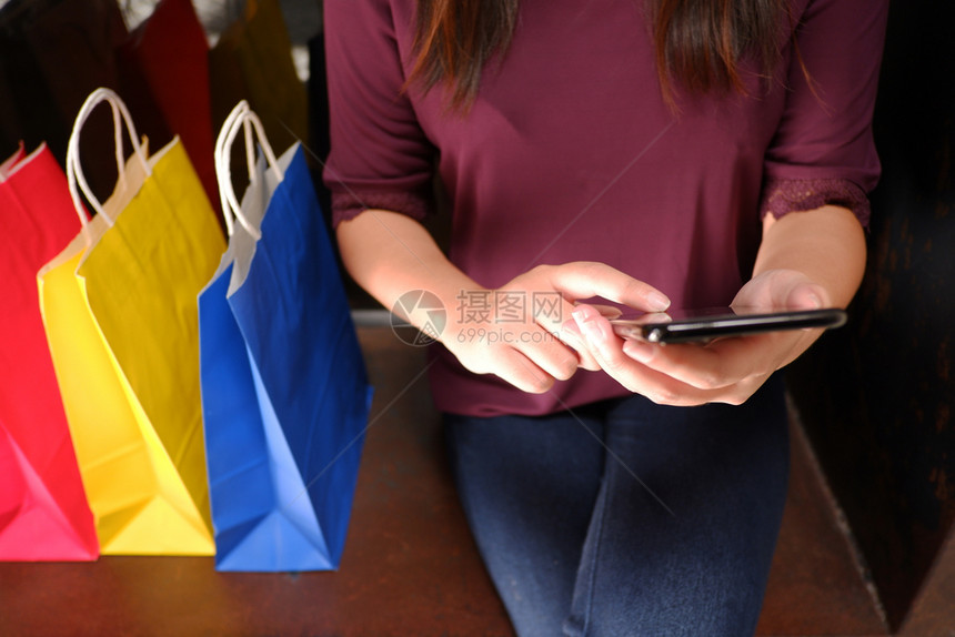 银行业女孩妇购物时使用智能手机的近身检查保持图片