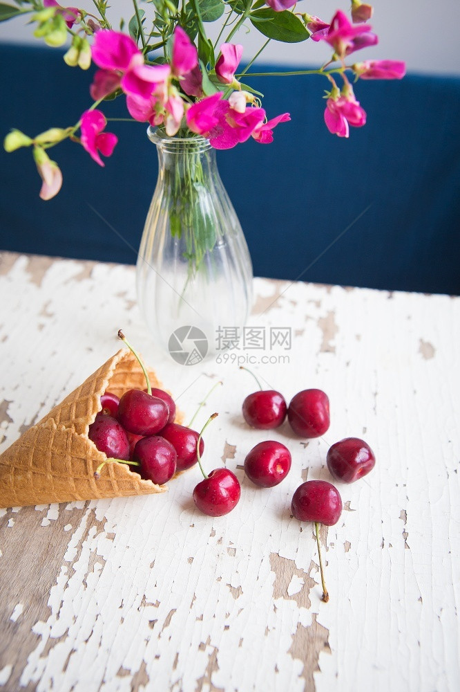 杯子甜的花瓶里粉红朵在华夫饼杯中的樱桃花躺在老旧的白桌子上花瓶里的朵在华夫饼杯中红色的图片