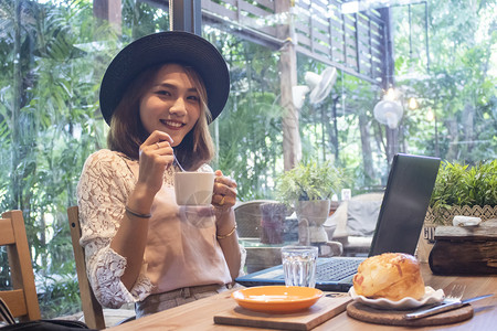 独自的球座在咖啡馆喝的年轻亚洲女人城市图片