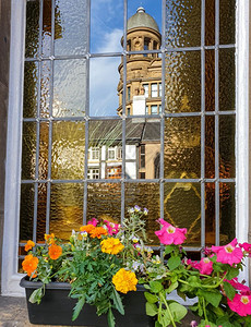 市中心建筑学前景在另一座古典建筑的窗户上在英国曼彻斯特的前方场上有一个花盆古典建筑窗口中的旧古典建筑反射背景图片