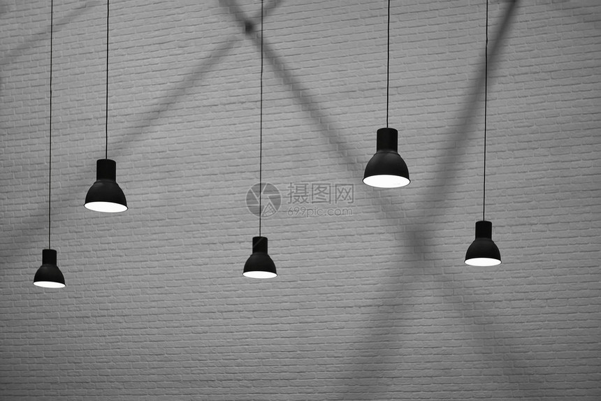 黑色的绞刑侧视图和有选择地聚焦5个挂着灯的具在黑白风格砖墙底色和白壁布面上闪光和影子内部建筑设计概念复古的图片