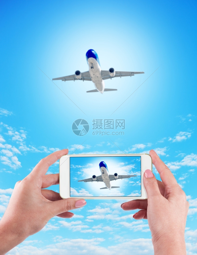 在蓝色背景上使用手机和飞的女手握在蓝色背景上使用手机和飞的女手电话小工具信息图片