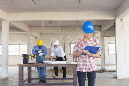 建筑工程师团队作安全信托小组负责在建筑工地硬帽子保护主任和土建工程师概念上安装白色黄全硬帽保设备C建筑工程师团队建设者人们体背景图片