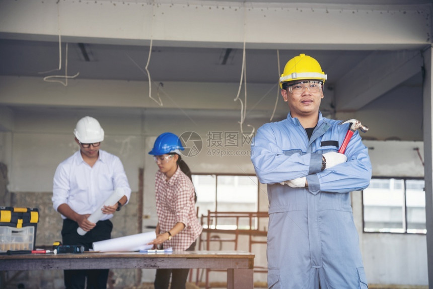 建筑工程师团队作安全信托小组负责在建筑工地硬帽子保护主任和土建工程师概念上安装白色黄全硬帽保设备C建筑工程师团队年轻的黄色白图片