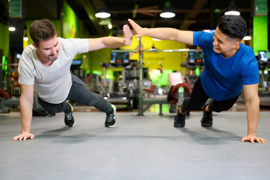 俯卧撑努力质量两个在健身房做高木板的年轻男子两个在健身房做高木板的年轻男子图片