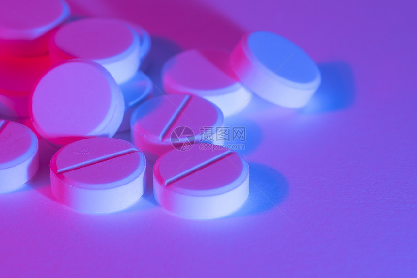霓虹灯光下的药物药片图片