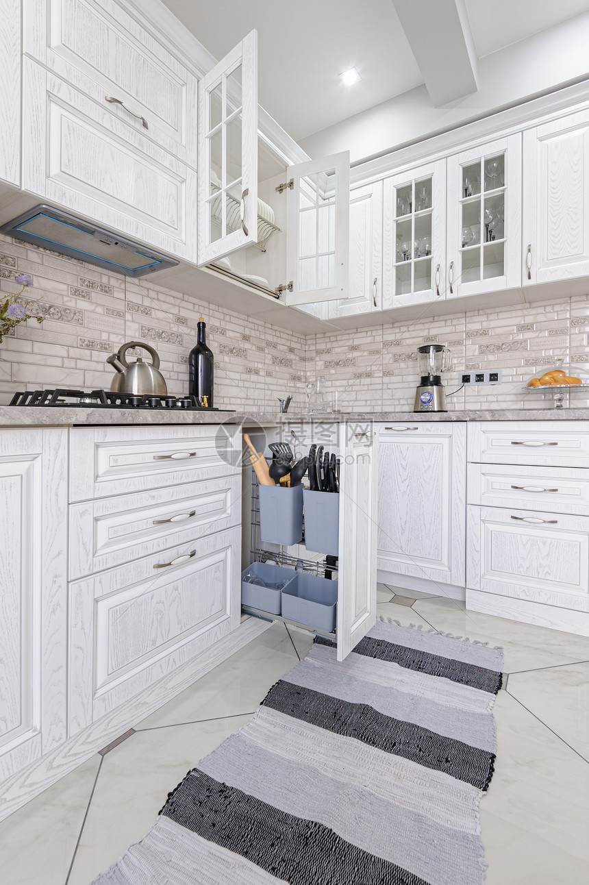 餐具奢华橱柜在豪住宅的现代白色木制厨房内一些抽屉是开放的现代白色木制厨房内图片