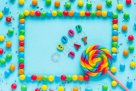 有色假期彩虹糖果背景文本好日彩信贺卡糖果和棒蓝背景顶视图平板铺设图片