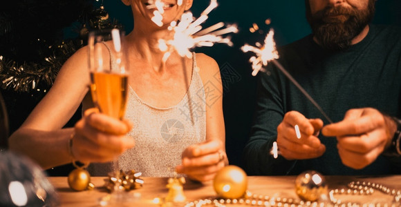 幸福的情侣拿着火花和香槟杯新年派对生日女朋友庆典图片