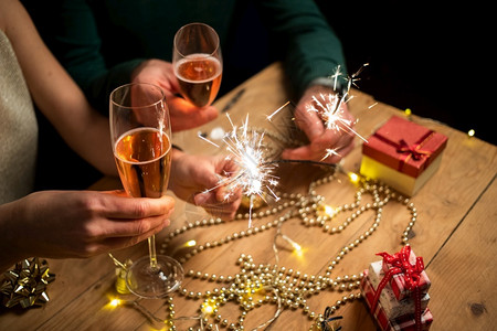 人们新的笑幸福情侣拿着火花和香槟杯新年派对图片