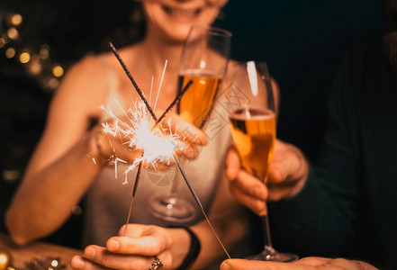 假期人们幸福的情侣拿着火花和香槟杯新年派对女图片