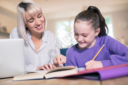 帮助年轻女孩学习的家庭辅导员女在职的坐着微笑图片